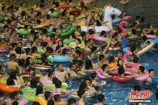 7月8日晚，民众在冲浪池中戏水。当日，为躲避持续高温闷热的天气，大批民众在夜色中涌进南京欢乐水魔方水上乐园戏水，在清凉中度周末。连日来，中国多地迎来高温天气。 中新社记者 泱波 摄