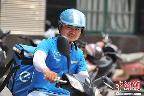 7月14日，在有“火炉”之称的江西南昌，一位送餐员“全副武装”骑着电动车准备送外卖。 中新社记者 刘占昆 摄