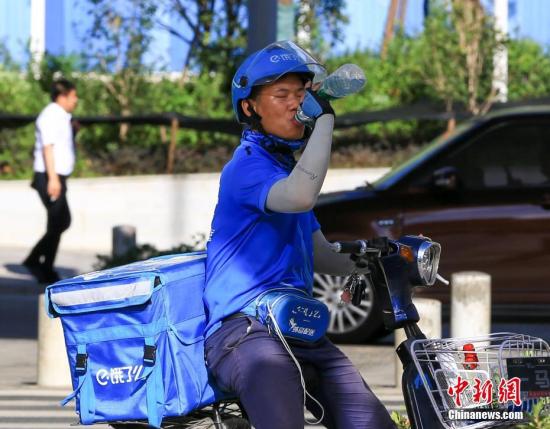 7月20日，武汉高温持续，送外卖的小哥喝水降温。中新社记者 张畅 摄