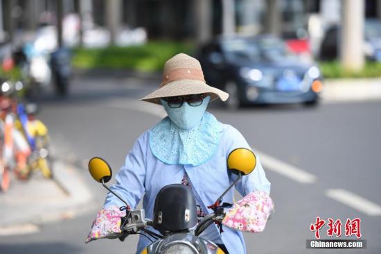 8月2日，广西南宁持续高温天，市民“捂装”出行。连日来，持续走高的气温，让南宁进入闷热的“桑拿天”。中新社记者 俞靖 摄