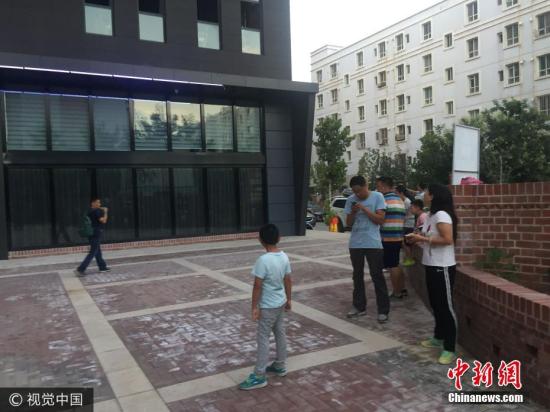 8月9日，新疆伊宁市有强烈震感，居民外出避险。高天 摄 图片来源：视觉中国
