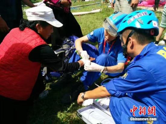 在地震灾区，甘肃志愿者为受伤民众处理伤口。 钟欣 摄