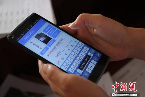资料图：浙江台州一位网格员正在利用手机对租客进行身份信息确认。中新社记者 王刚 摄