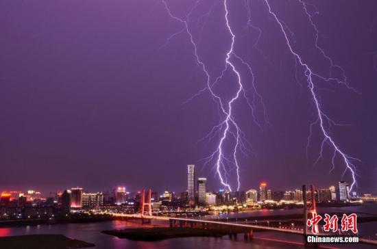 8月12日晚间，江西省会南昌突降暴雨，城市夜空电闪雷鸣。长长的闪电不时划过天空，“霹”向高楼大厦，场景十分震撼。 江依 摄