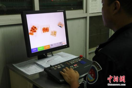 资料图：安检人员对货邮进行x光检查并填写申报单。中新社记者 刘占昆 摄