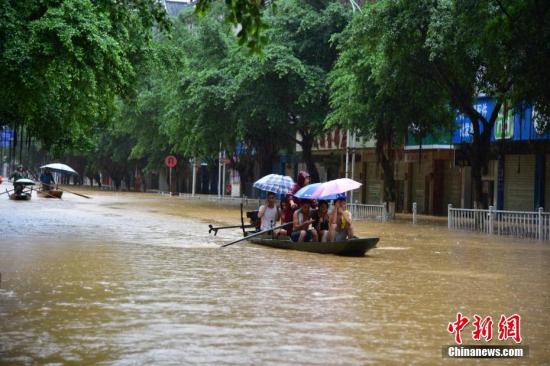 8月14日，受流域内持续强降雨影响，广西柳州市融水苗族自治县融江河水暴涨，县城老城区被淹，居民只得乘船出行。中新社记者 王以照 摄