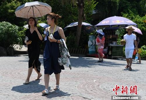 8月15日，厦门市民在高温烈日下出行。当日，福建省气象台继续发布高温橙色预警信号。中新社记者 张斌 摄