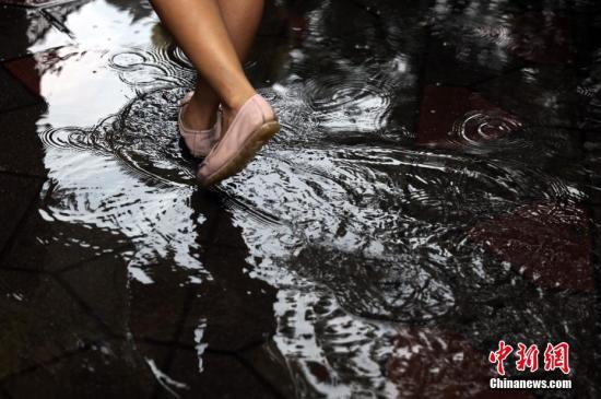资料图片，行人在雨中出行。中新社记者 杨可佳 摄