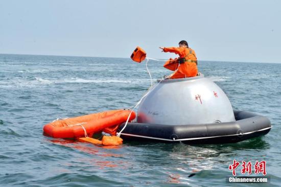 16名中国航天员和2名欧洲航天员，8月21日在山东省烟台市附近海域圆满完成了为期17天的海上救生训练任务。图为训练期间，8月17日，航天员尝试从神舟飞船模拟返回舱“逃离”。 中新社发 朱九通 摄
