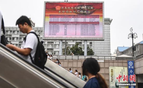 资料图：济南火车站广场大屏幕24小时循环播放失信被执行人信息。中新社记者 张勇 摄