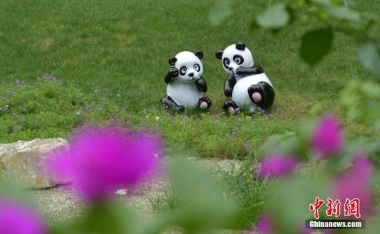 资料图：成都三环路边草丛中的熊猫雕塑。 中新社记者 刘忠俊 摄