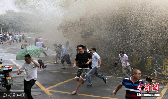 资料图：市民和游客在钱塘江杭州段观看“鬼王潮”。吴煌 摄 图片来源：视觉中国