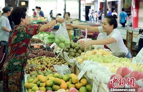 资料图：农贸市场内民众正在购买水果。中新社记者 刘忠俊 摄