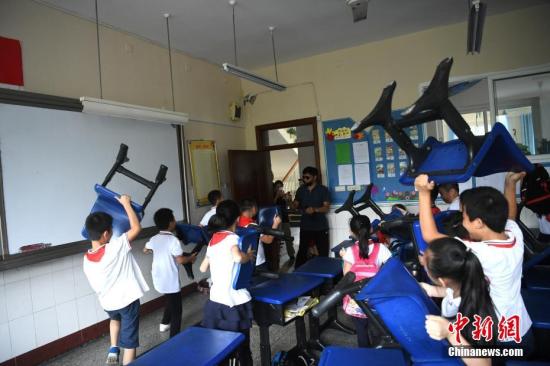 资料图：9月25日，重庆南岸区天台岗小学花园校区内举行反恐防暴演练。图为小学生们正在练习如何用身边工具来保护自己。中新社记者 陈超 摄