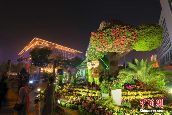9月30日晚，北京市街头的“美好生活”国庆主题花坛景致绚丽，吸引民众观灯赏花。中新社记者 贾天勇 摄