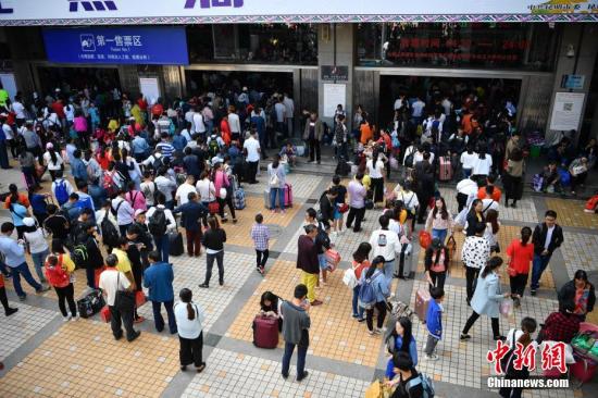 资料图：昆明火车站售票区外排队的旅客。中新社记者 刘冉阳 摄