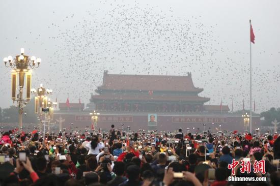 10月1日，数万民众在北京天安门广场观看国庆升旗仪式。中新社记者 盛佳鹏 摄