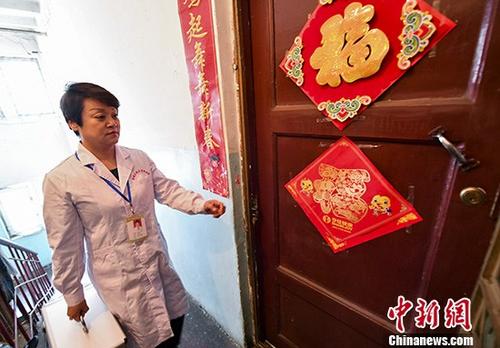 新疆乌鲁木齐市北京路社区卫生服务中心医生司娟，拎着便民医药箱前往附近居民家中回访巡诊。司娟同时是一名家庭医生，她和她的团队已与周边1000多个家庭签约，针对签约居民的不同需求，提供不同的健康。中新社记者 刘新 摄