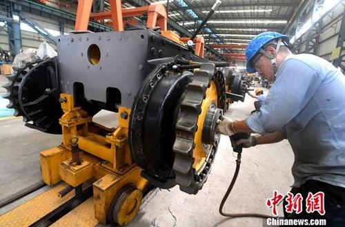 图为厦工(三明)重型机器有限公司工人在生产线上作业。(资料图片)中新社记者 张斌 摄