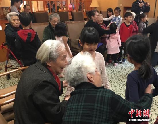 资料图：养老院的老人们与幼儿园小朋友一起做游戏。中新社记者 杜燕 摄