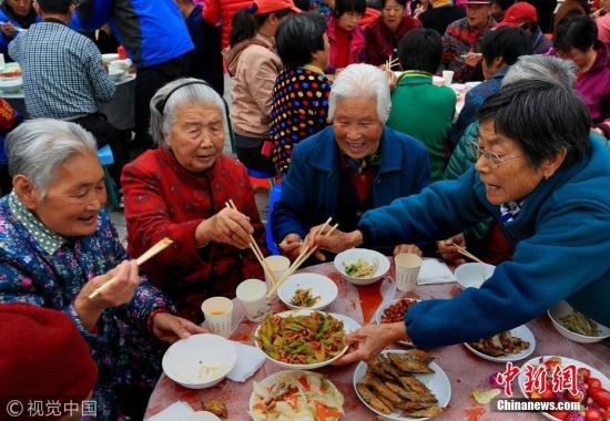 资料图：北京一乡村老人正在开心地同吃“重阳节和睦百家宴”。 图片来源：视觉中国