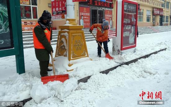 11月14日，内蒙古呼伦贝尔市牙克石街头，环卫工在清理积雪。余昌军 摄 图片来源：视觉中国