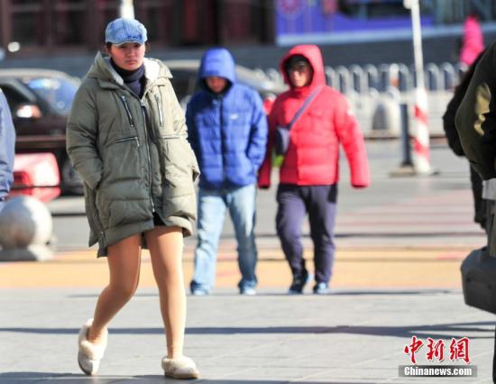 11月29日，辽宁沈阳，市民穿着冬装出行。当日，受冷空气影响，沈阳最高气温为-5℃，最低温仅为-14℃。 中新社记者 于海洋 摄