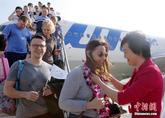 资料图：去往海南旅游的游客受到热烈欢迎。中新社记者 尹海明 摄