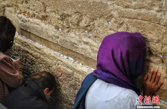 资料图：哭墙又称西墙，是耶路撒冷旧城古代犹太国第二圣殿护墙的一段，也是第二圣殿护墙的仅存遗址，长约50米，高约18米，由大石块筑成。图为在哭墙祷告的犹太教徒。中新网记者 李雨昕 摄