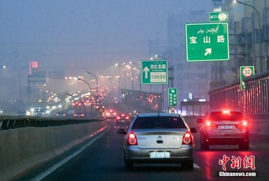 12月20日傍晚时分，华灯初上的新疆乌鲁木齐市依旧被雾霾天气所笼罩。 中新社记者 刘新 摄