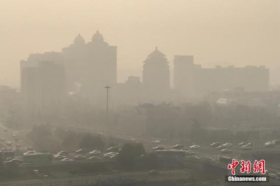 资料图：12月29日，雾霾中的北京建国门桥地区。中新社记者 李慧思 摄