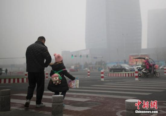 北京市民在雾霾中出行。中新社记者 刘关关 摄
