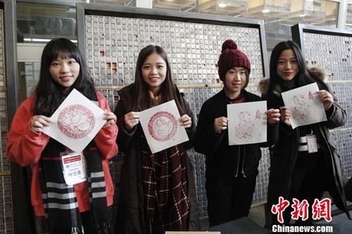 1月26日，来北京参加2018寒假台湾青年学生中华文化研习营的80余位台湾师生来到武英造办博物馆，体验传统造纸和印刷工艺。图为台生与自己制作的雕版印刷作品合影。中新社记者 陈小愿 摄
