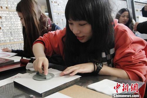 1月26日，来北京参加2018寒假台湾青年学生中华文化研习营的80余位台湾师生来到武英造办博物馆，体验传统造纸和印刷工艺。图为台生体验雕版印刷。中新社记者 陈小愿 摄