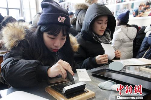 1月26日，来北京参加2018寒假台湾青年学生中华文化研习营的80余位台湾师生来到武英造办博物馆，体验传统造纸和印刷工艺。图为台生体验活字印刷。中新社记者 陈小愿 摄