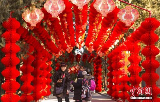 2月2日，北京地坛公园，市民经过挂满红灯笼的通道。随着农历春节的临近，北京城年味渐浓。中新社记者 侯宇 摄