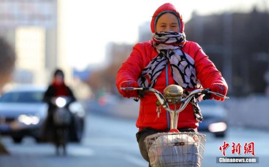 资料图：2月2日，北京民众在低温寒风中出行。 中新社记者 杨可佳 摄