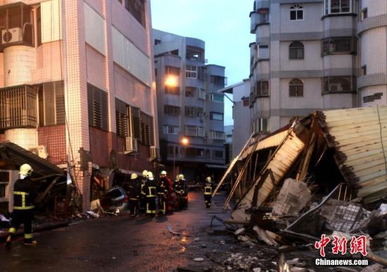 2月7日傍晚，救援人员正在台湾花莲市区国盛六街上两栋相邻大楼间勘查，展开震后救援。两栋大楼均受损严重。6日深夜，花莲近海发生里氏6.5级地震，市区多栋大楼倒塌或倾斜，造成大量人员伤亡，数十人失联。中新社记者 黄少华 摄