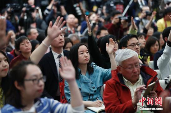 3月2日，媒体记者在新闻发布会上举手提问。当日，全国政协十三届一次会议新闻发布会在北京人民大会堂一层新闻发布厅召开，大会新闻发言人王国庆向中外媒体介绍本次大会有关情况并回答记者提问。中新社记者 杜洋 摄