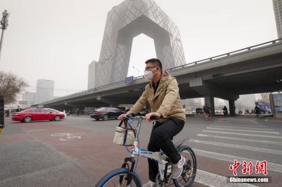 3月28日，北京民众在沙尘天气中出行。当日，北京市气象台发布沙尘蓝色预警。 中新社记者 贾天勇 摄