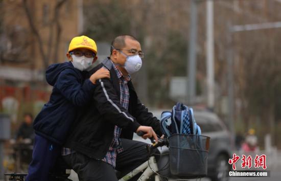 3月28日，北京民众戴口罩在街头出行。当日，雾霾沙尘齐聚京城，除此前启动的空气重污染橙色预警之外，官方还发布了今年首个沙尘蓝色预警。在两者“夹攻”之下，全城空气质量已达到严重污染水平。 中新社记者 杨可佳 摄