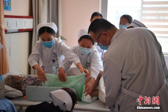 资料图：医生在检查病人情况。 中新社记者 刘冉阳 摄