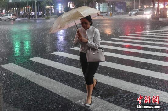 5月7日，广州街头，一名女子撑伞行走在雨中。 中新社记者 陈骥� 摄