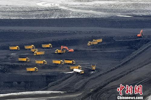 7月4日，位于新疆准东经济技术开发区，新疆天池能源有限责任公司所属的南露天煤矿，大型运输车辆正在深达200米左右的矿坑中忙着转运原煤。准东煤田位于新疆准格尔盆地东部，东西长达220公里的茫茫戈壁下蕴藏着3900亿吨煤炭资源，已探明储量2149亿吨，是中国目前最大的整装煤田。准东煤田包括五彩湾、大井、将军庙、西黑山、老君庙5个矿区，其中4个矿区规划已取得国家批复。 中新社记者 刘新 摄