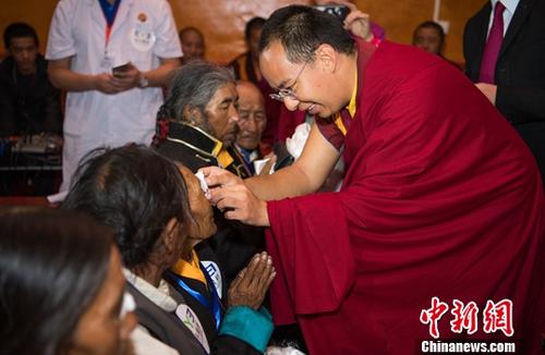 7月31日，援助西藏发展基金会、爱尔眼科医院集团“日喀则慈善光明行”捐赠仪式在日喀则的扎什伦布寺举行。仪式上，援助西藏发展基金会理事长班禅额尔德尼・确吉杰布为术后的白内障患者代表揭开纱布并赠送护目眼镜。中新社记者 何蓬磊 摄