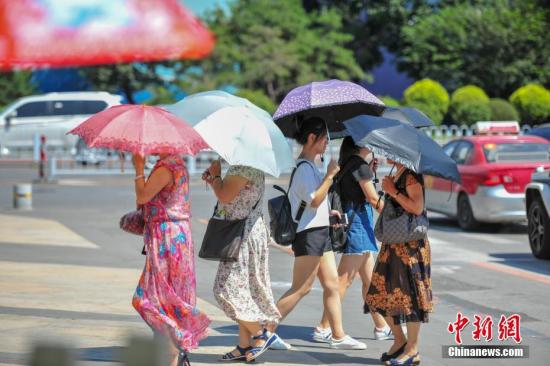 8月2日，沈阳街头，市民撑遮阳伞在高温天出行。当日，沈阳最高气温度达37℃，开启“清蒸模式”。中新社记者 于海洋 摄