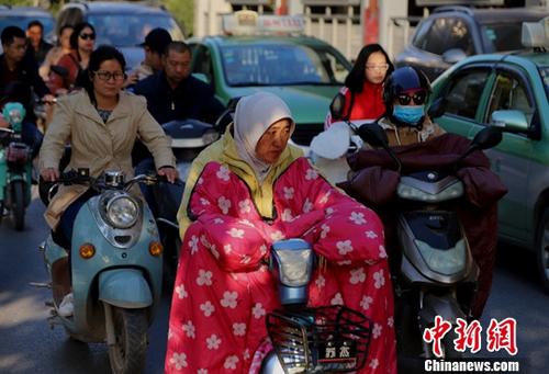 10月10日，河南郑州，受冷空气影响，气温骤降，民众包裹严实出行。中新社记者 王中举 摄
