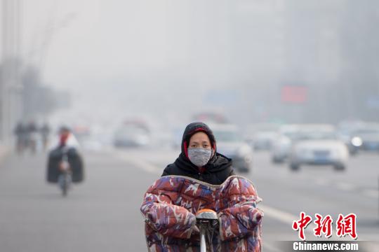 1月7日，山西省太原市被重度霾笼罩，民众戴口罩出行。　韦亮　摄