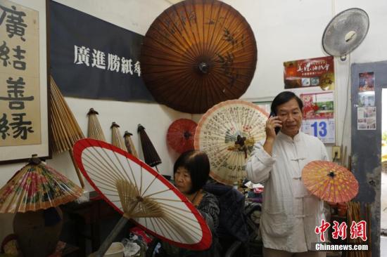 近日，台湾高雄美浓油纸伞传承人林荣君（右），在广进胜纸伞工作室接受了中新社记者专访。中新社记者 陈小愿 摄