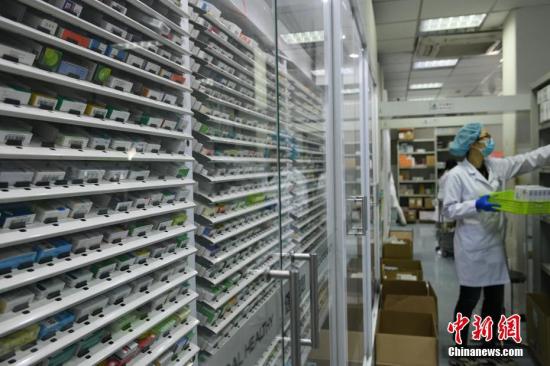 资料图：药剂师通过自动分药系统为患者准备药品。 中新社记者 佟郁 摄